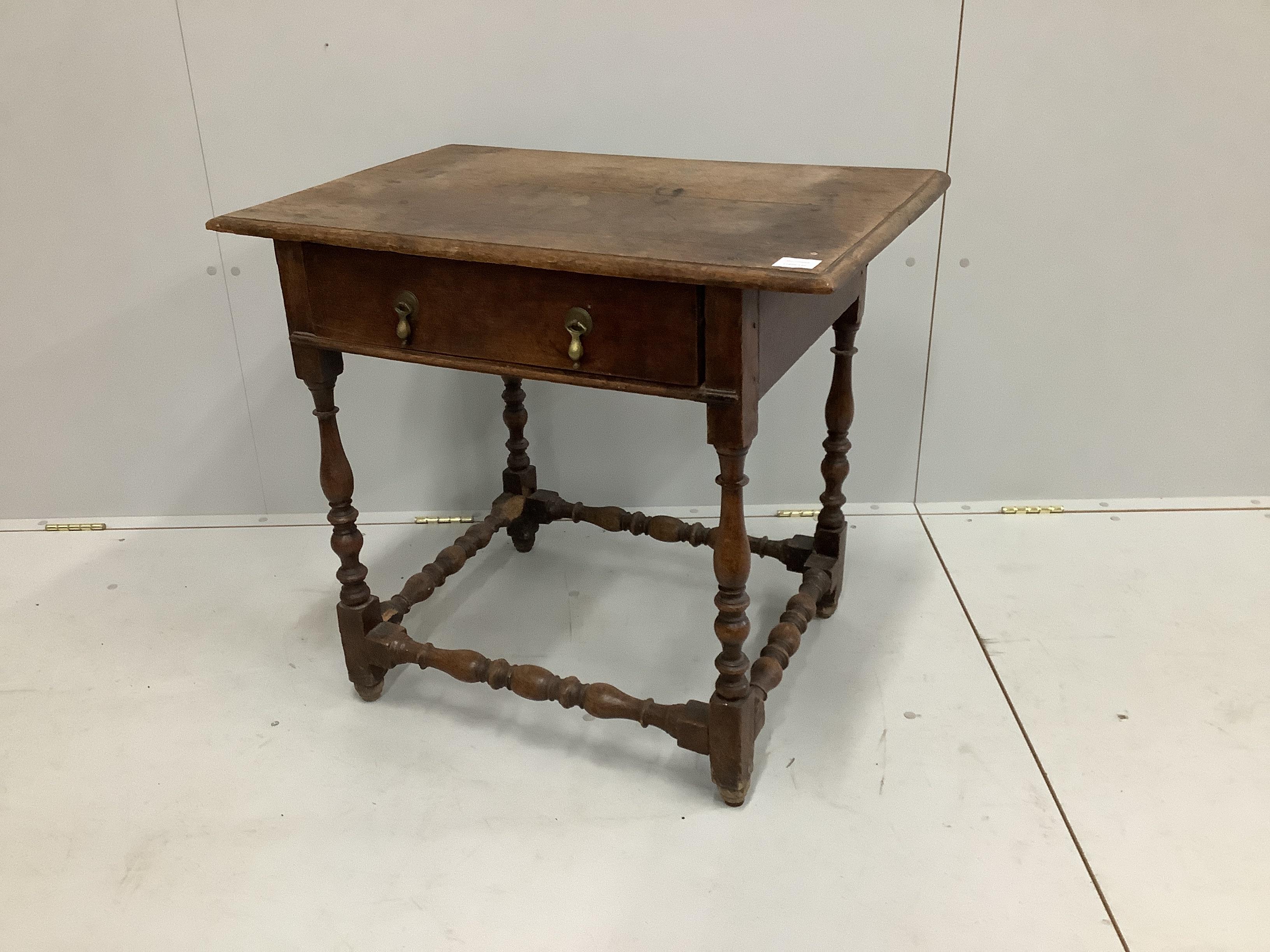 An 18th century rectangular oak side table with planked top and single drawer raised on turned supports and castors, width 78cm, depth 51cm, height 69cm
